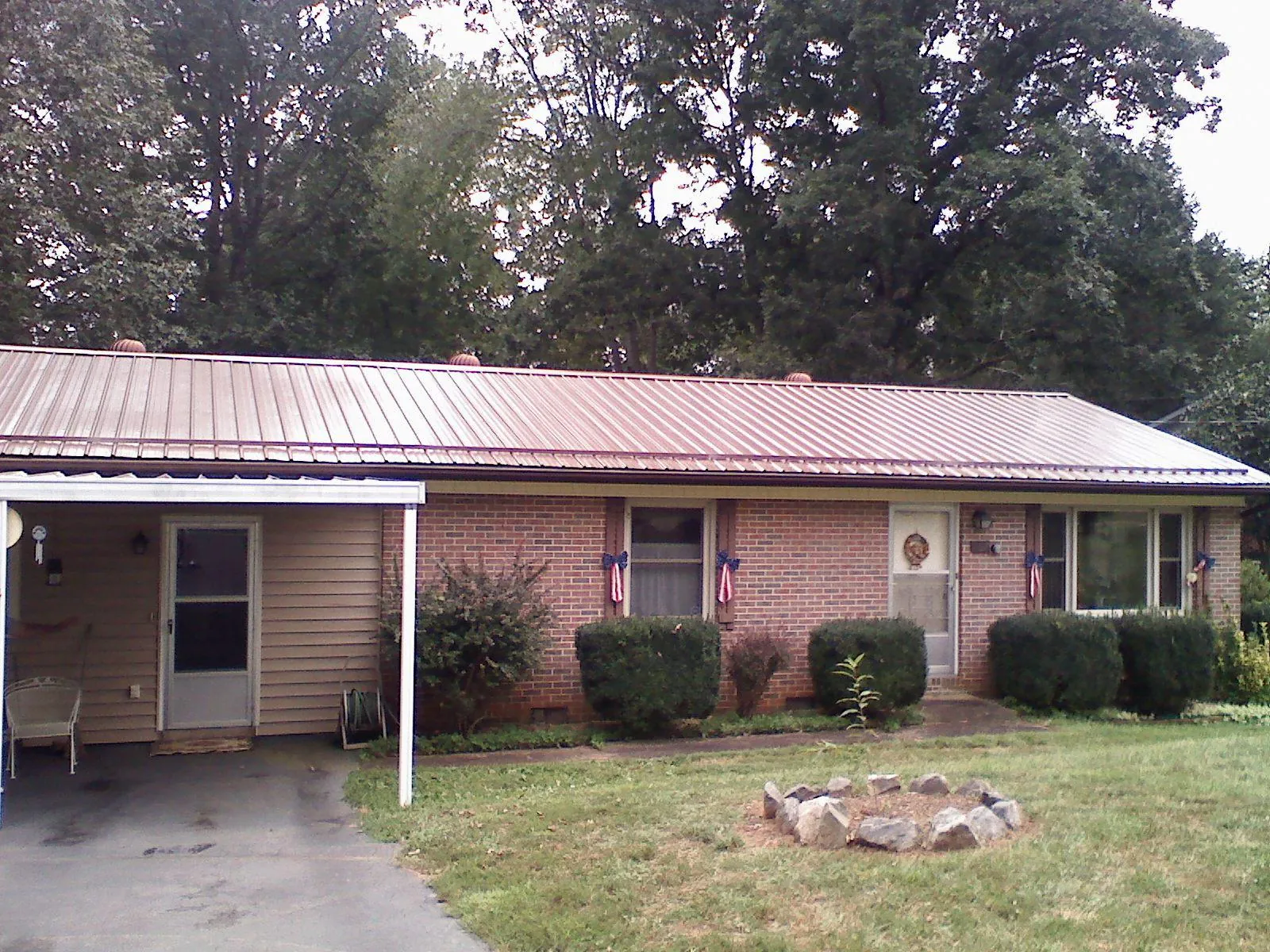 Bronze metal roof and carport on a brick ranch home — Roof Repair work by our crew in Friendsville
